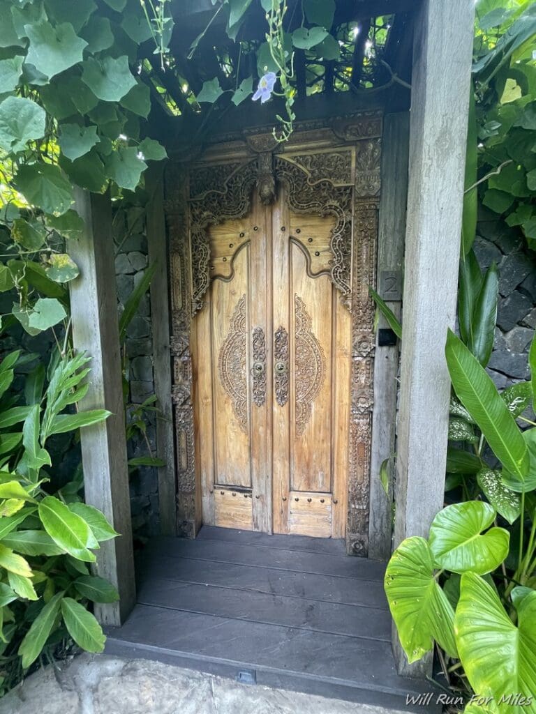 a wooden door with a wood frame and plants