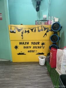 a yellow sign with black text and a laundry basket