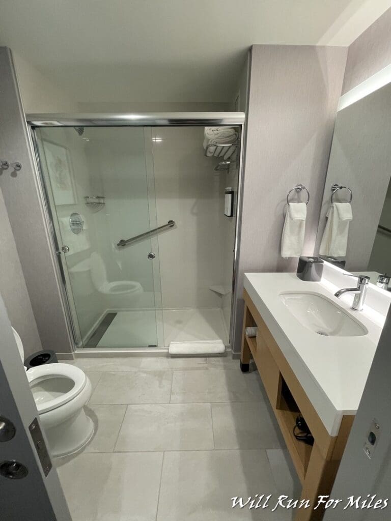 a bathroom with a glass door and sink