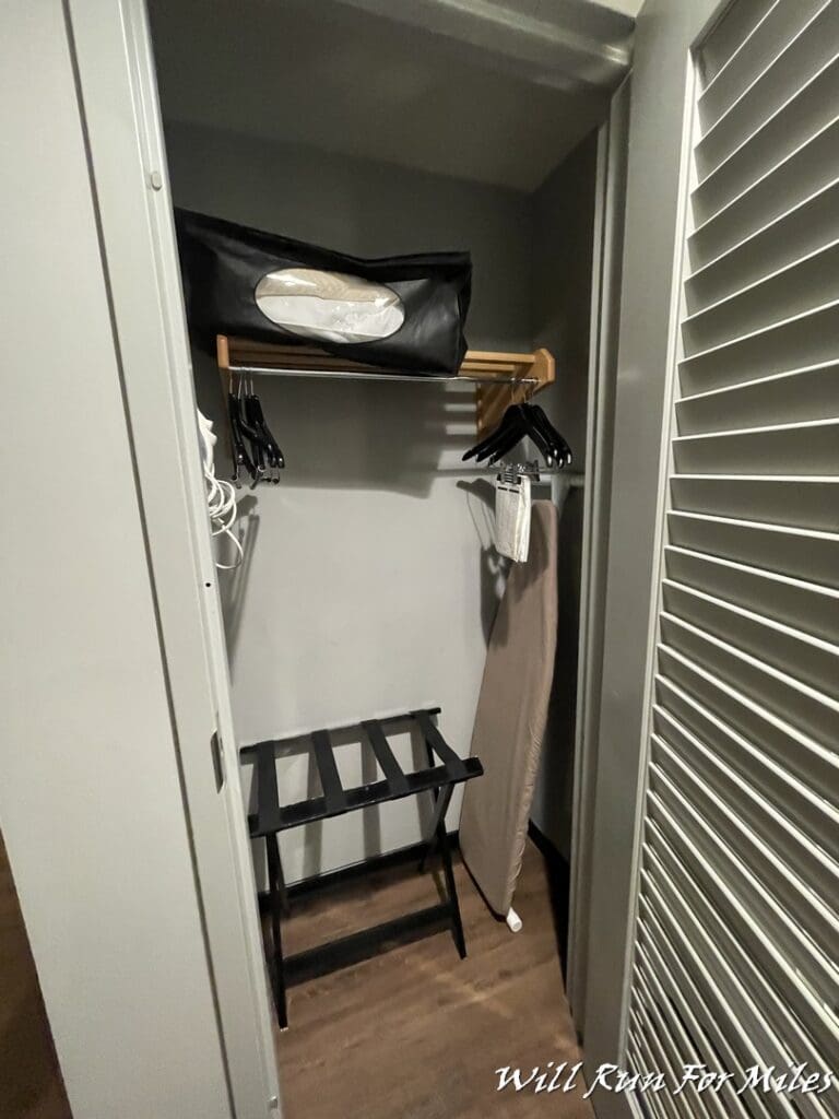 a closet with a shelf and swingers