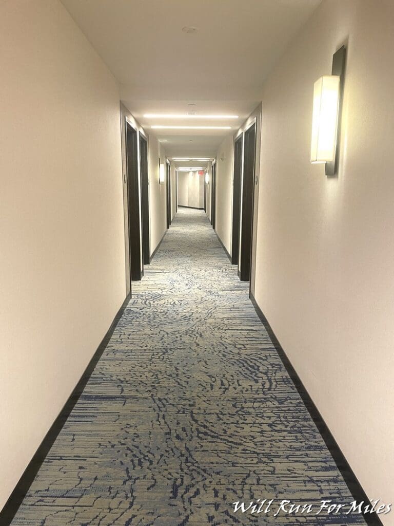 a hallway with a blue carpet and lights