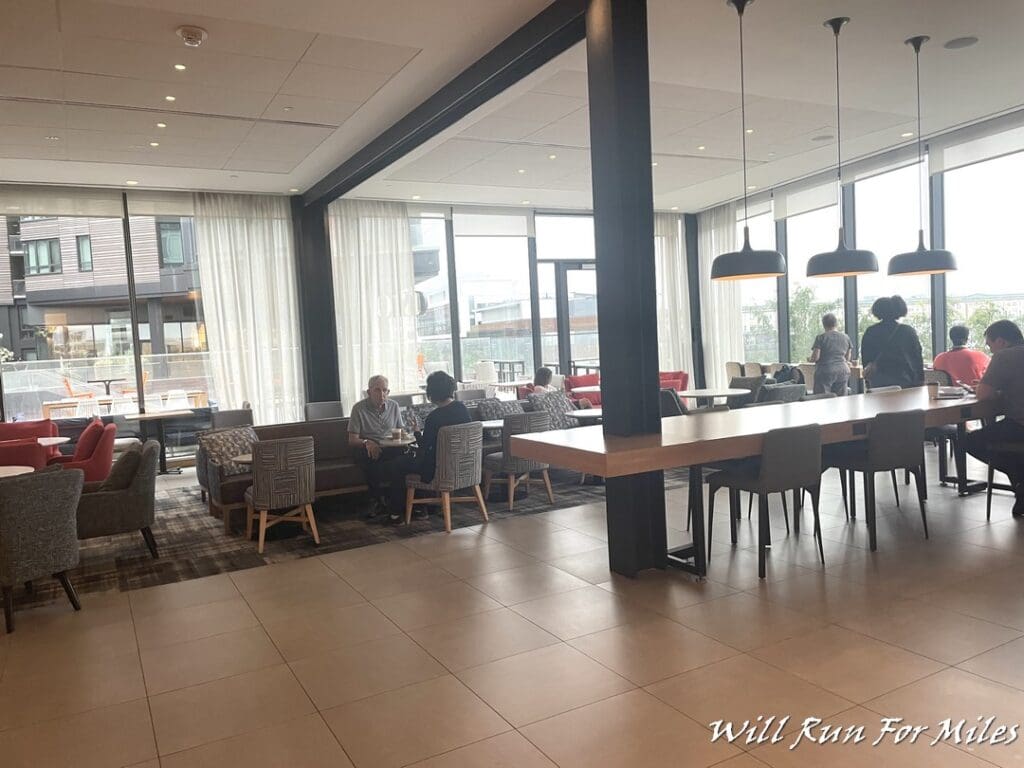 a group of people sitting at tables in a room with windows