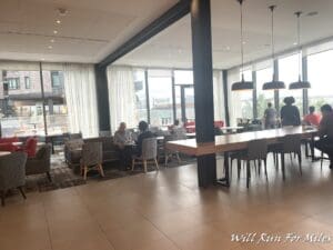 a group of people sitting at tables in a room with windows