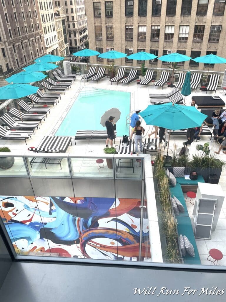 a pool with umbrellas and chairs on a rooftop