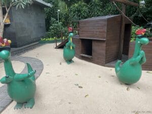 a green dinosaur statues in a playground