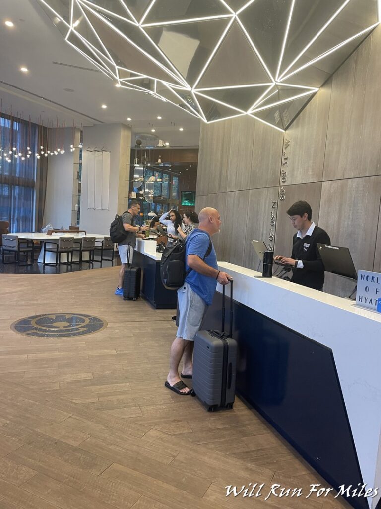 a man standing at a reception desk with luggage