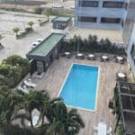 a pool and a building with trees and cars