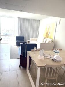a room with a table and chairs and a chair and a table with a luggage