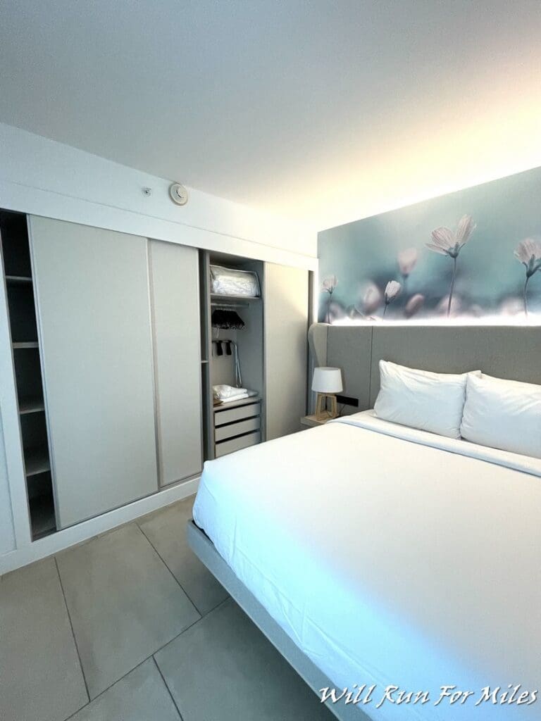 a bed with white sheets and a white wall above it