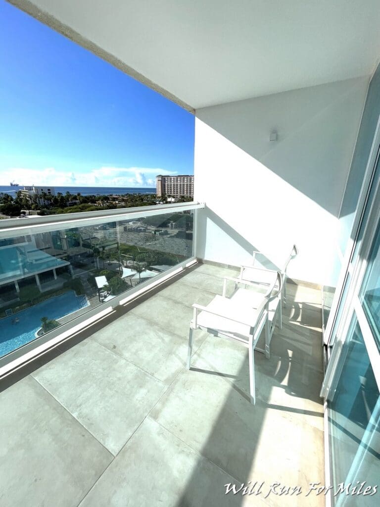 a balcony with chairs and a view of the ocean