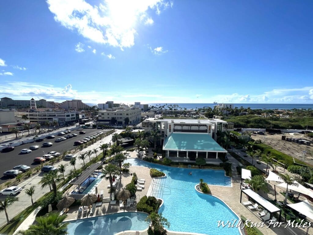 a swimming pool and a building with cars and buildings in the background