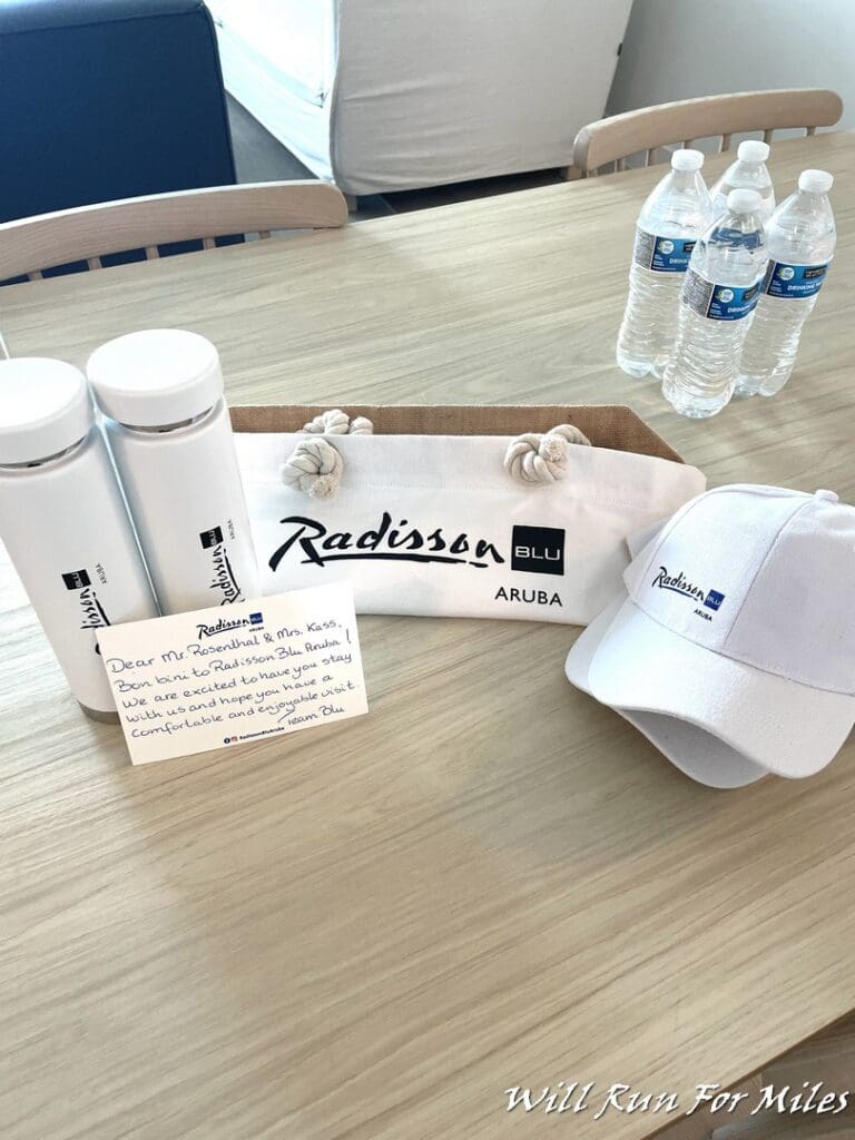 a table with a bag of water bottles and a hat