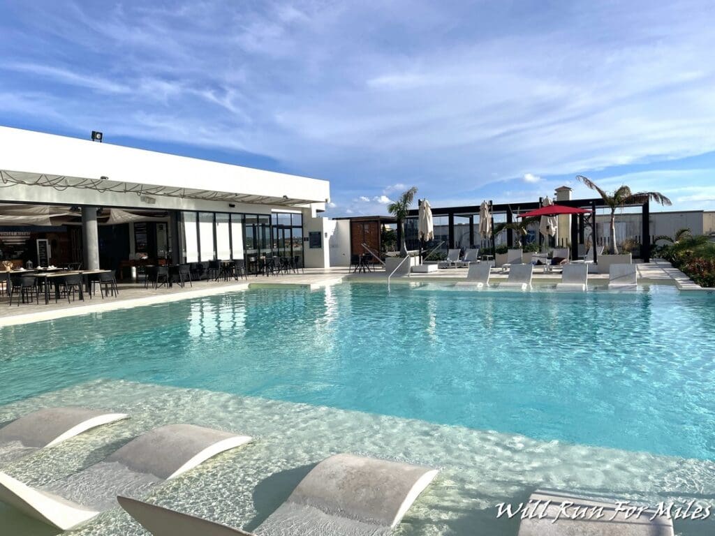 a pool with chairs and a building