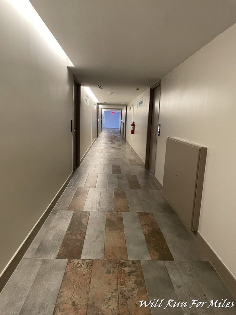 a hallway with doors and a tile floor