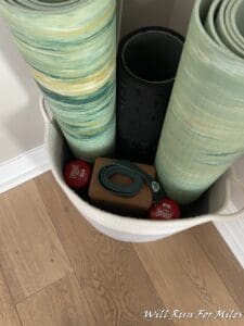 a group of rolled up yoga mats in a basket