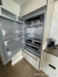 a refrigerator with shelves and a coffee maker