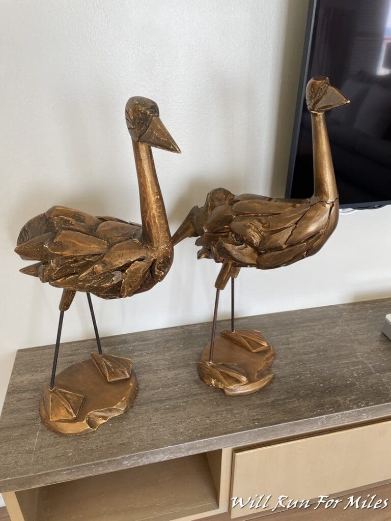 two statues of birds on a table