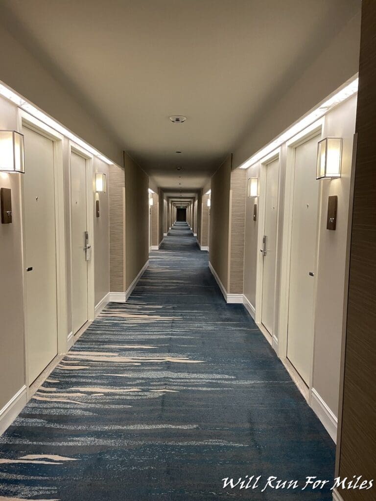 a long hallway with doors and lights