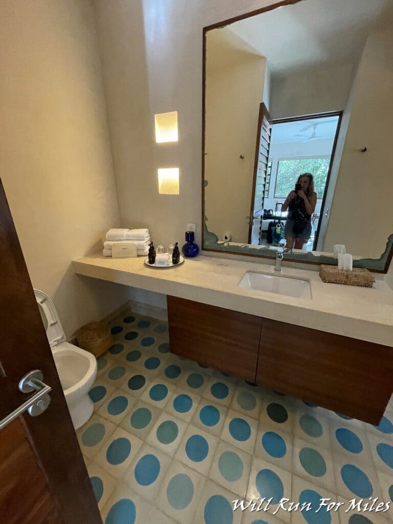 a woman taking a picture of a bathroom