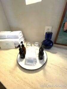 a plate with a small dish with a small bottle of liquid and a towel on it