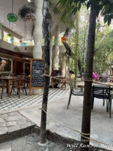 a group of people sitting at tables and chairs in a courtyard