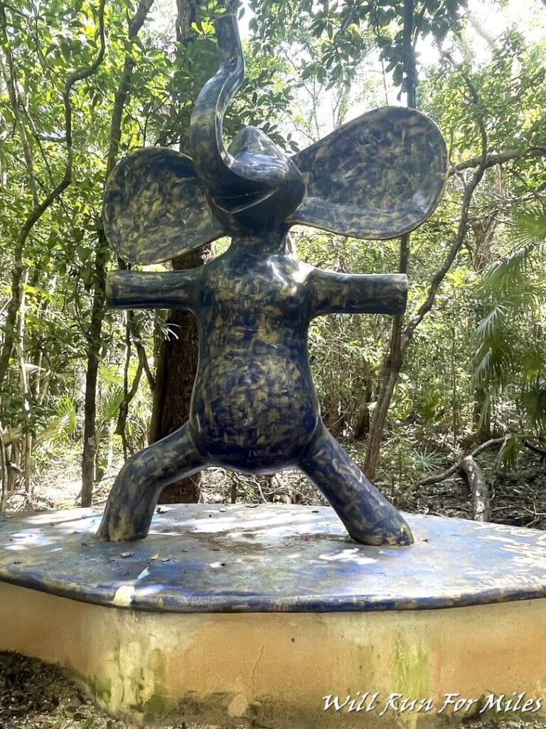 a statue of an elephant in the woods