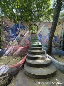 a colorful wall with a staircase and a mural on it