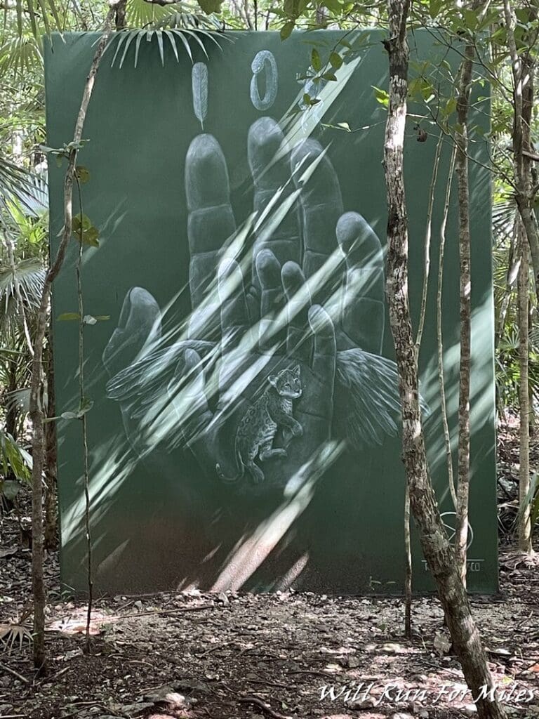 a painting of a hand and a lizard in the woods