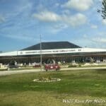 a building with a large roof and a parking lot