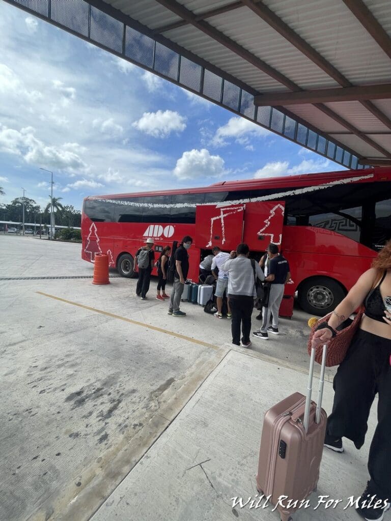 a group of people standing next to a red bus