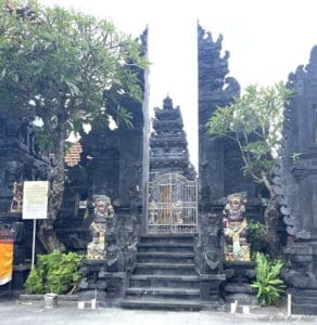 a stone building with a gate and statues