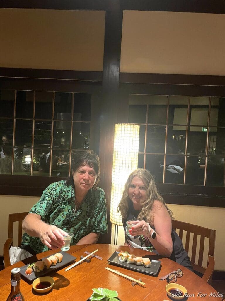 a man and woman sitting at a table with food