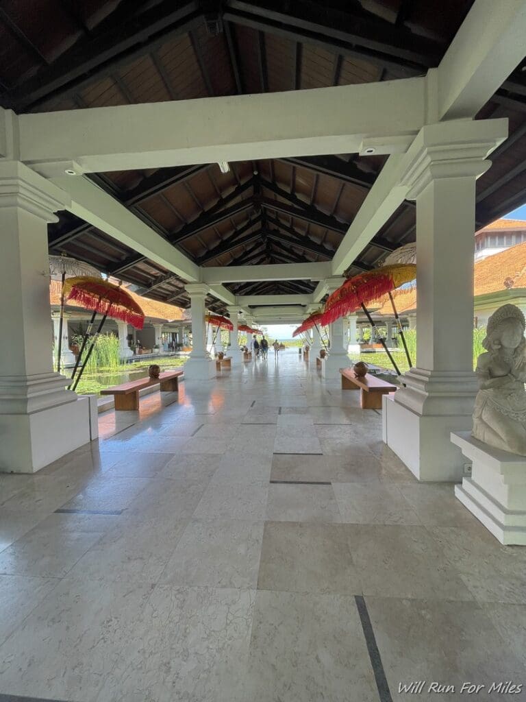 a walkway with benches and umbrellas