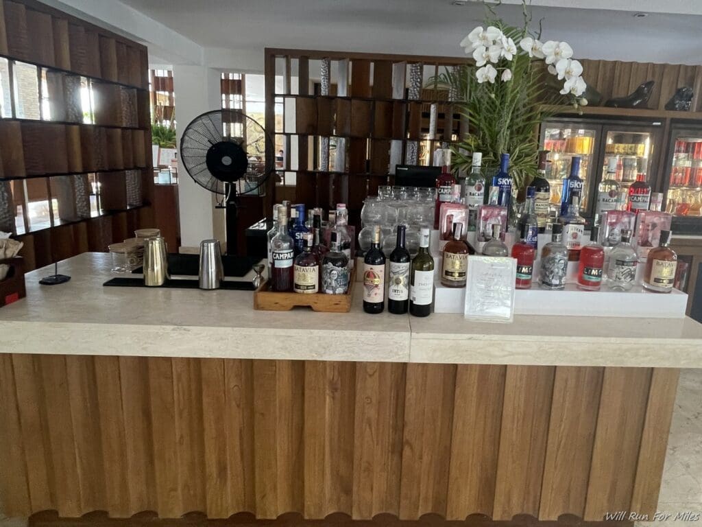 a bar with bottles of alcohol and a fan