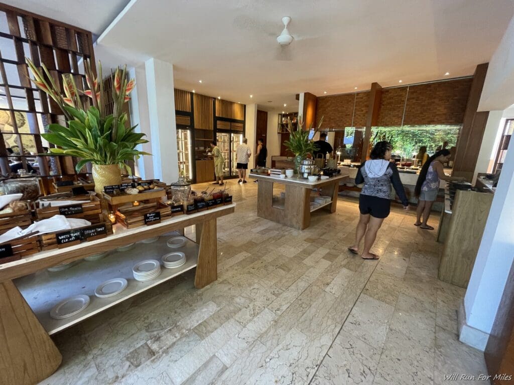 a room with a buffet and people walking around