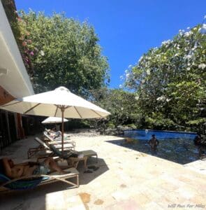 a pool with people sitting in chairs and umbrellas