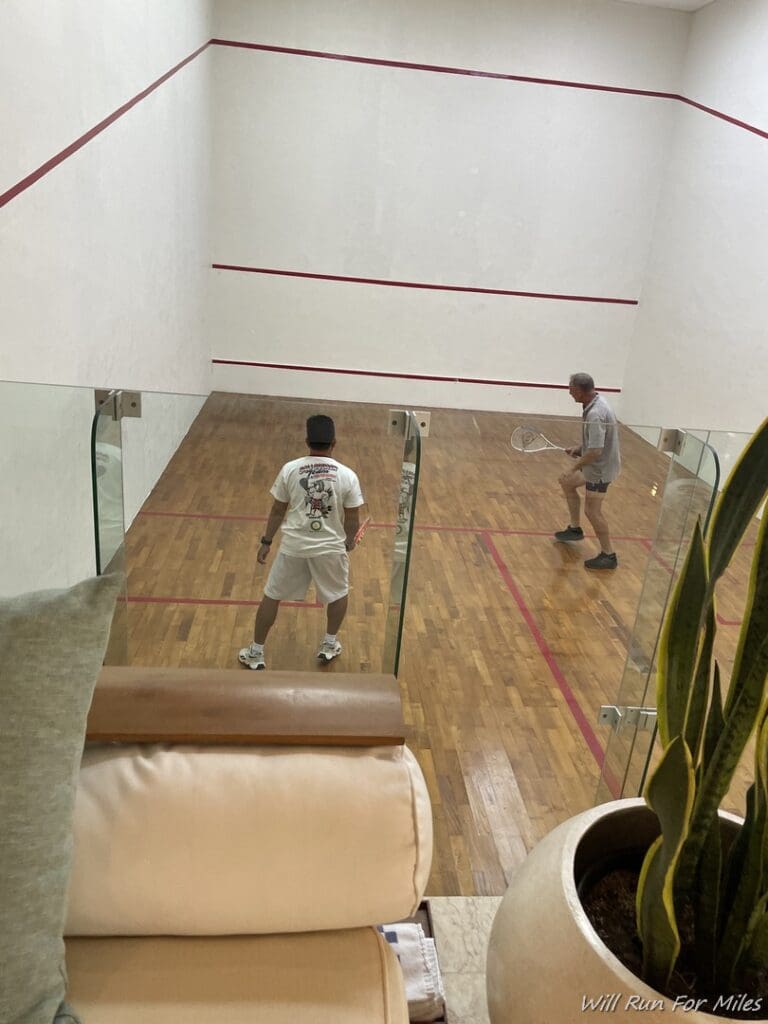 a man holding a racket in a squash court