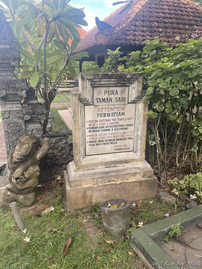 a stone monument with a statue in front of a building