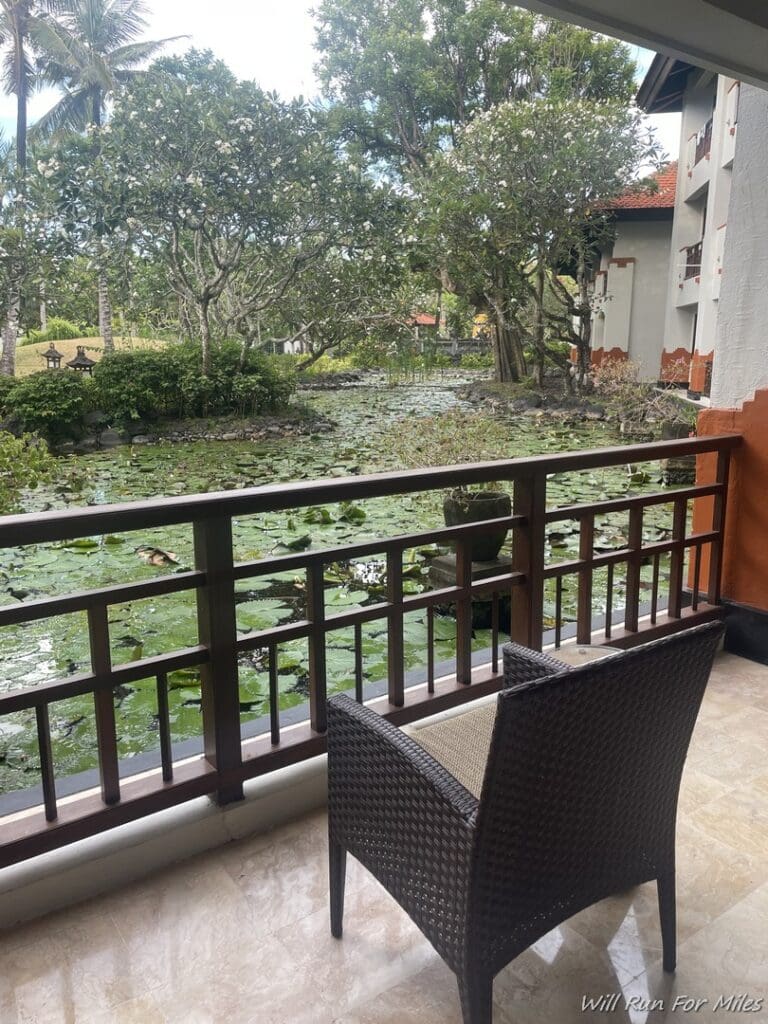 a chair on a balcony overlooking a pond