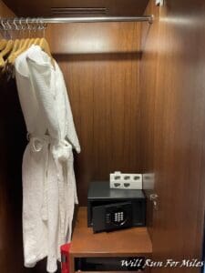 a white robe on a swinger with a small black safe