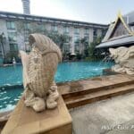 a stone fish statues next to a pool