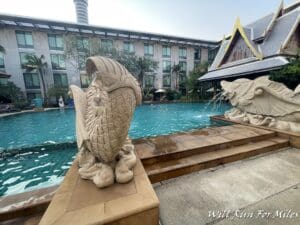 a stone fish statues next to a pool