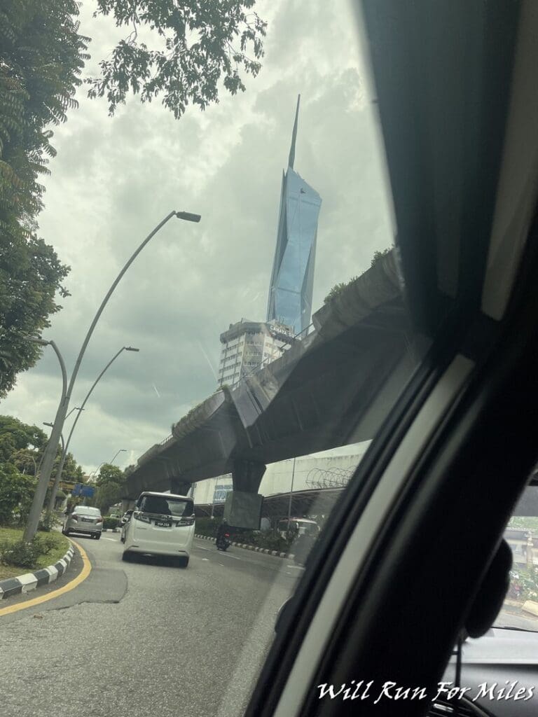a view from a car window of a city street with a tall building