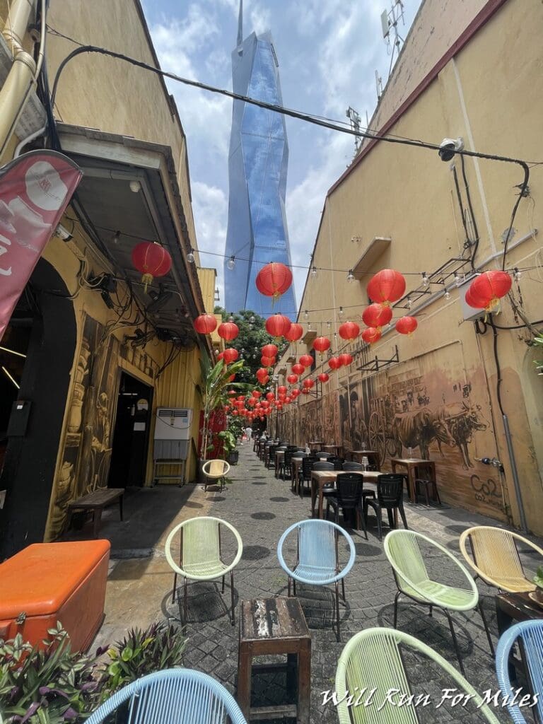 a street with tables and chairs and red lanterns