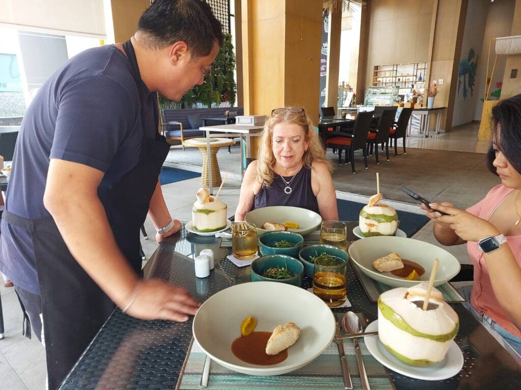 a man and woman sitting at a table with food
