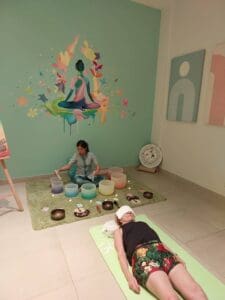 a woman sitting on a rug with bowls on it