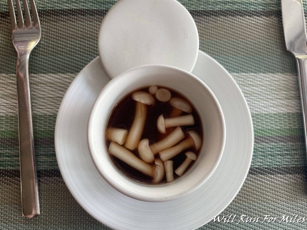 a cup of soup with mushrooms in it