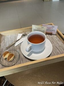 a tray with a cup of tea and a small plate of bread