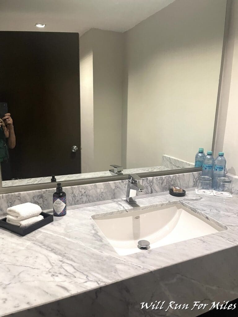 a bathroom sink with a mirror and bottles of liquid on it