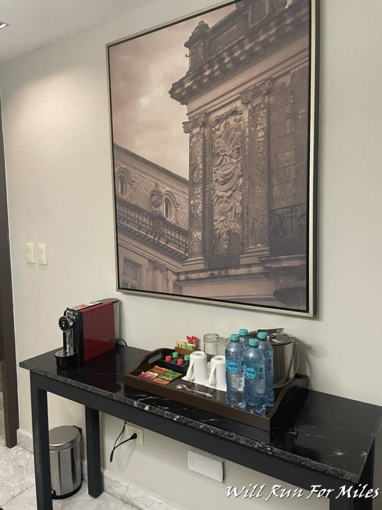 a tray with water bottles and a coffee machine on a table